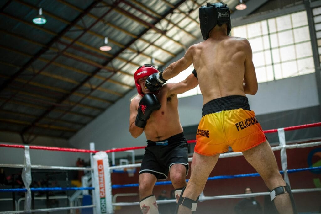 Two fighters in a boxing ring during a live combat sports event